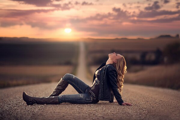 Una ragazza in un vestito di jeans si trova sulla strada