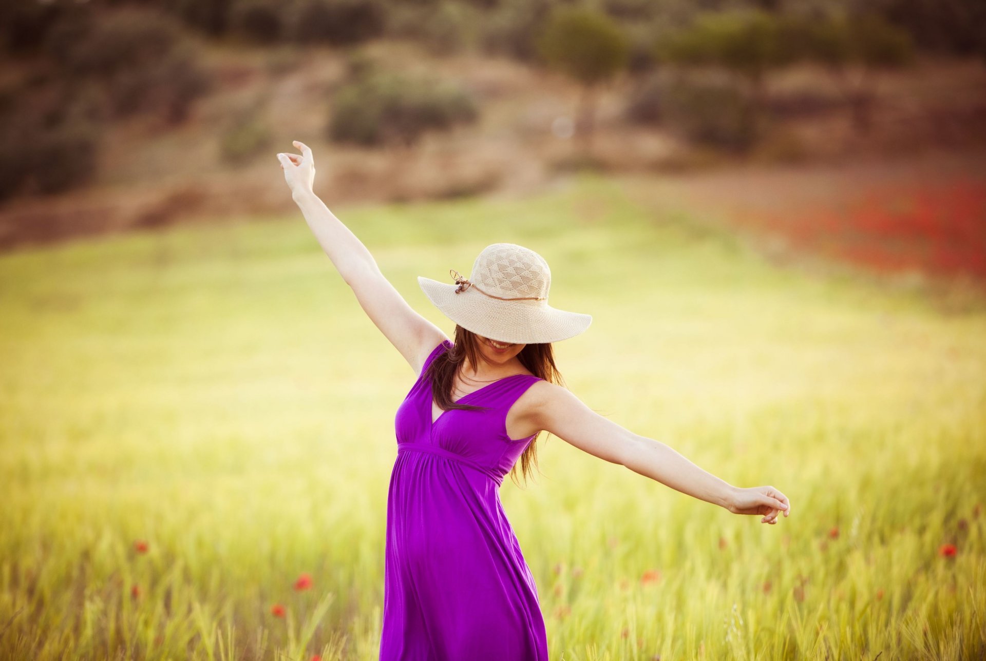 humeur fille brunette femme mains robe pourpre chapeau sourire joie bonheur positif liberté se détendre champ fleurs fleurs arbres arbre feuillage feuilles flou arrière-plan papier peint grand écran plein écran écran large