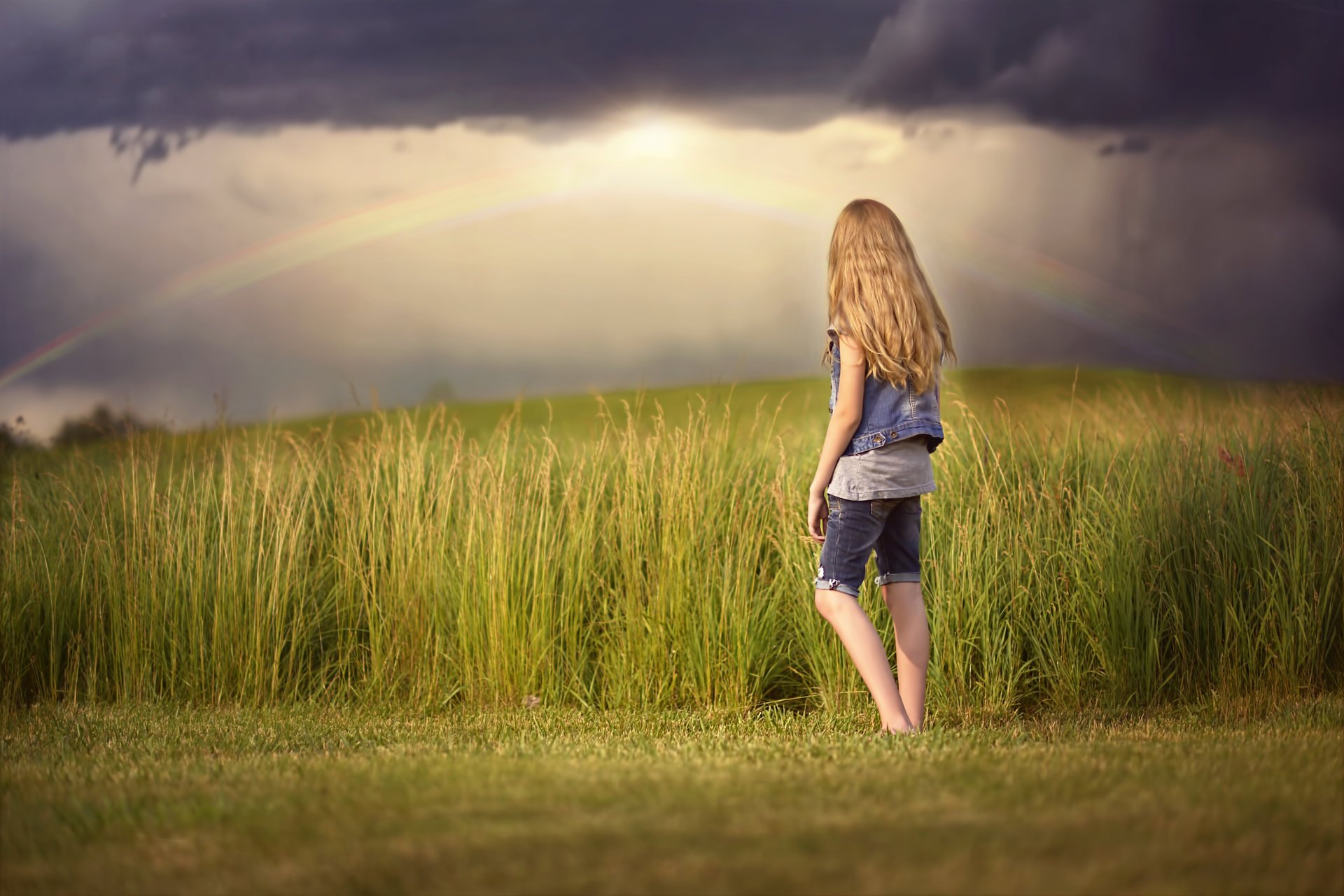 chica arco iris nubes campo