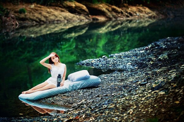 The girl woke up early in the morning on the bank of the river