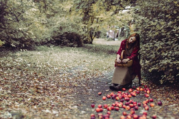 The girl scattered apples and is sad