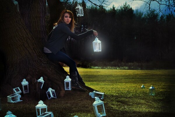 The girl at the tree at night with lanterns