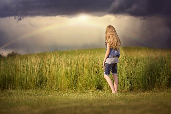 La niña en el campo Mira el cielo gris