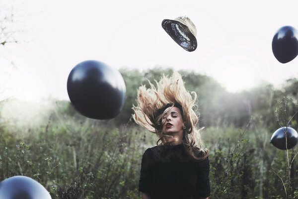 A girl with a hat on a background of black balls