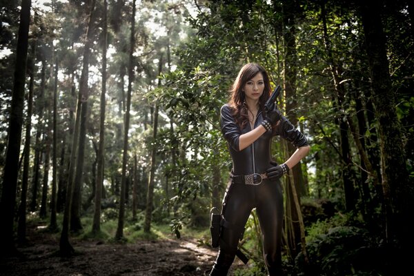 Fille avec un pistolet seul au milieu de la forêt