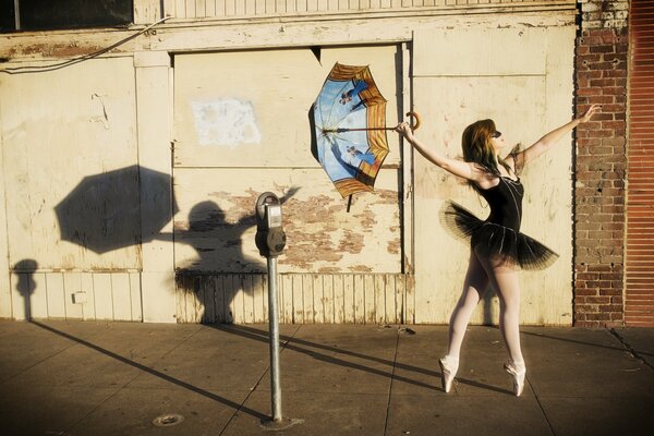 Bailarina chica en la calle con un paraguas