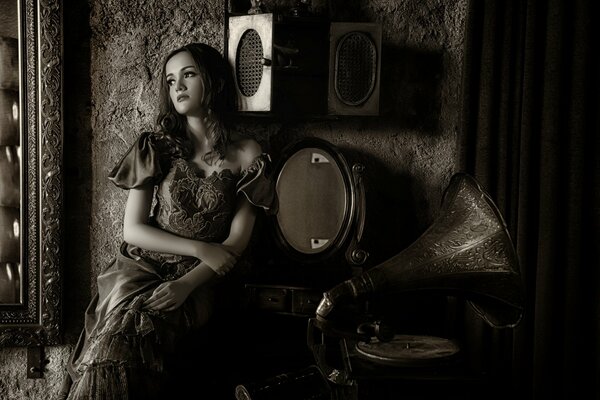 Una chica con un vestido Vintage escucha un gramófono