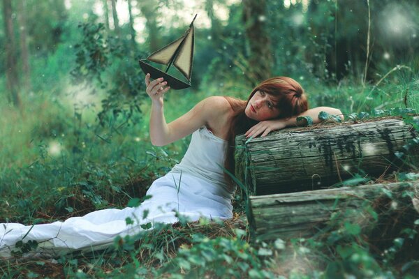 Fille avec un bateau sur fond de forêt