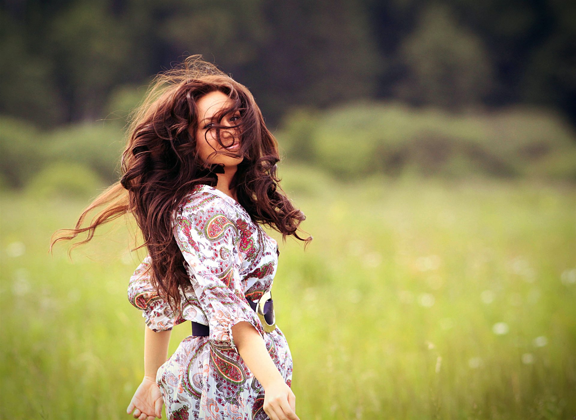 fille cheveux bruns boucles cheveux sourire nature champ herbe