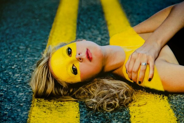 A girl with road markings on her face and body