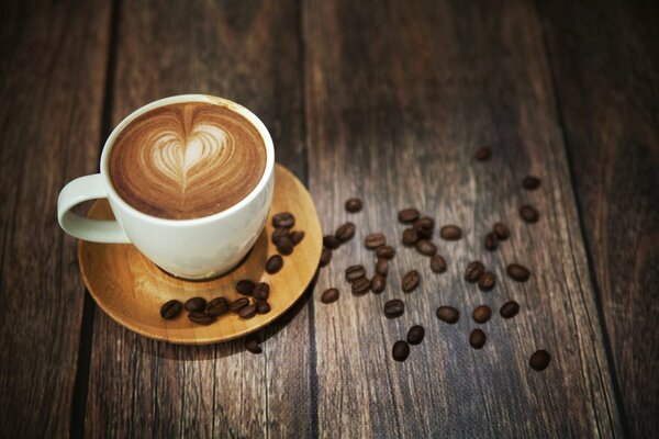 Taza de café de espuma de grano en la mesa