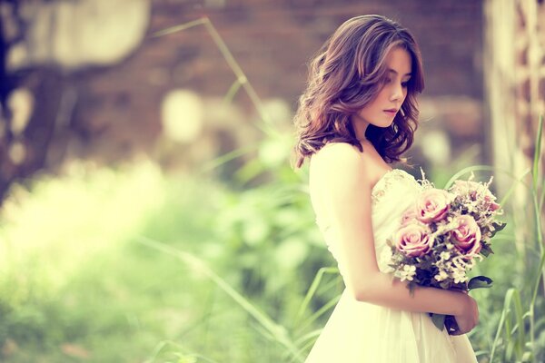 The bride with flowers is photographed in nature