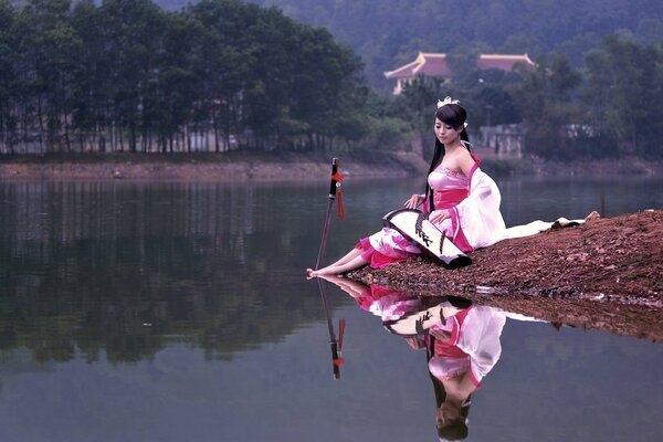 A beautiful girl and a gun near the lake