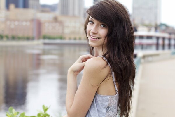 Chica con el pelo de chocolate en el fondo de la ciudad