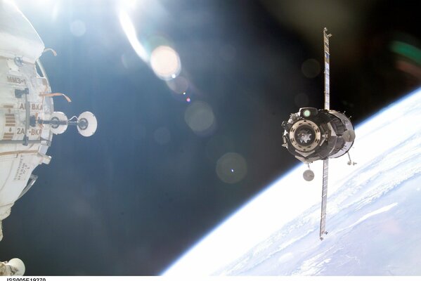 The docking of the capsule with the ISS in space, against the background of the earth