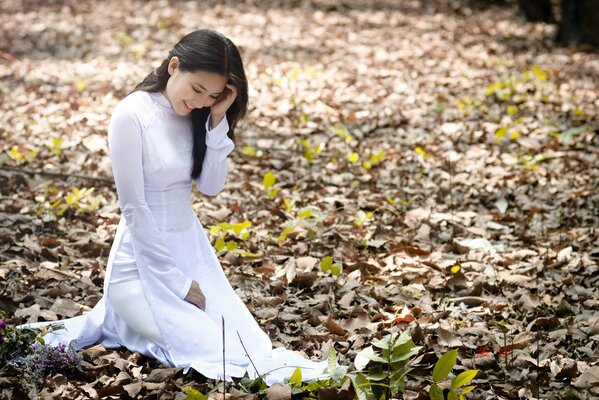 Fille en robe blanche se dresse sur les feuilles d automne