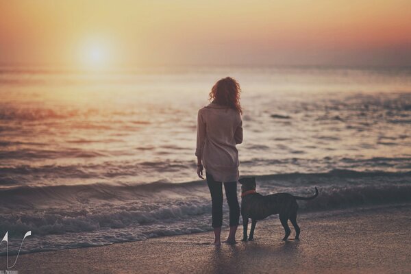 Mädchen mit Hund am Seeufer am Abend