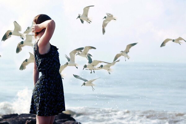 Mädchen im schwarzen Kleid am Meer