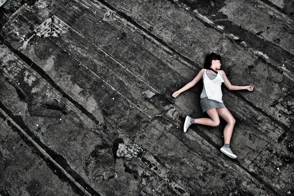 The brunette is lying on the roofing material after a fall