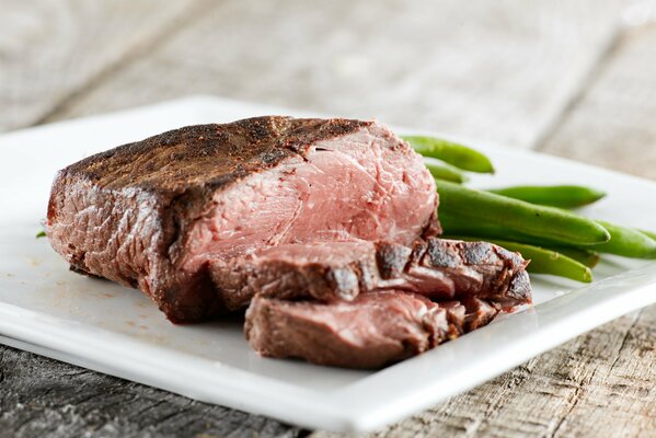 Steak de boeuf aux haricots verts sur une assiette