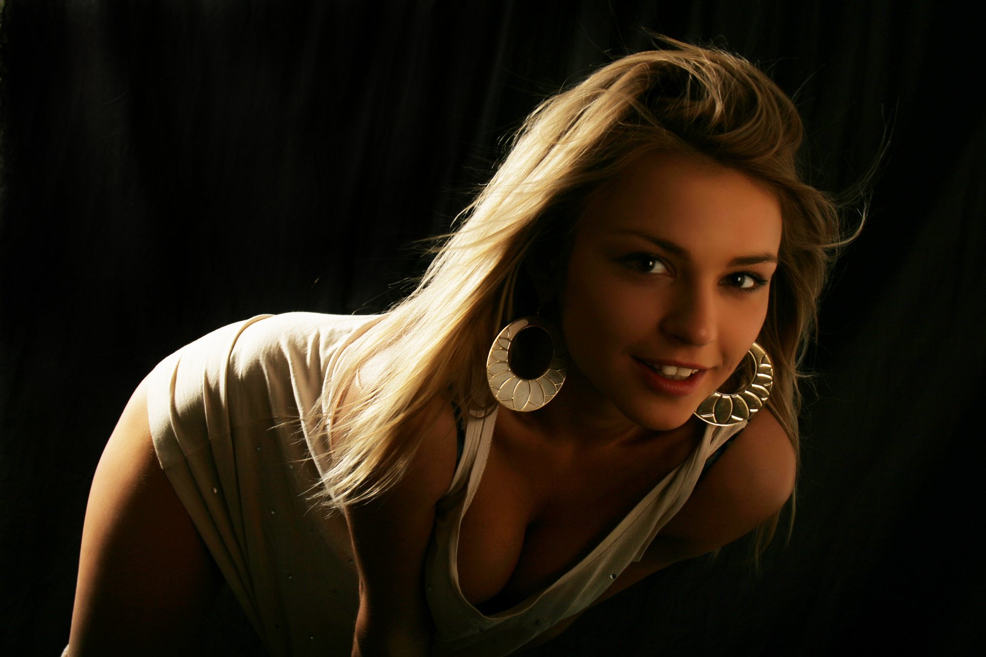 fille belle poitrine pose sourire sombre regard blond débardeur boucles d oreilles