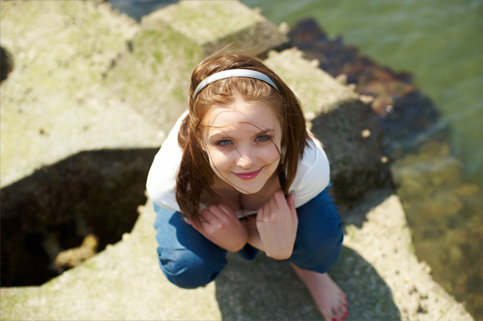 ragazza bruna cerchio sorriso sguardo t-shirt pietra acqua vento