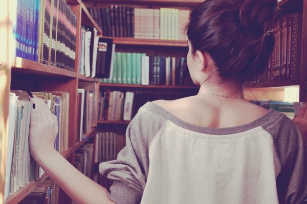 A girl in a sweatshirt in a bookstore