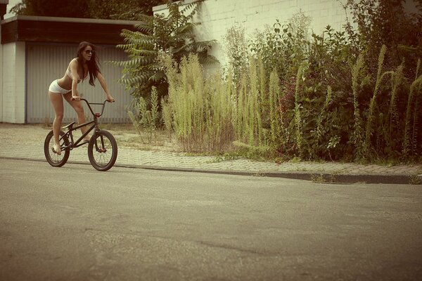 Mädchen in Dessous reitet ein Fahrrad