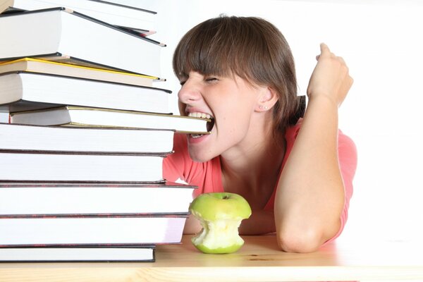 A girl with an apple and a stack of study books