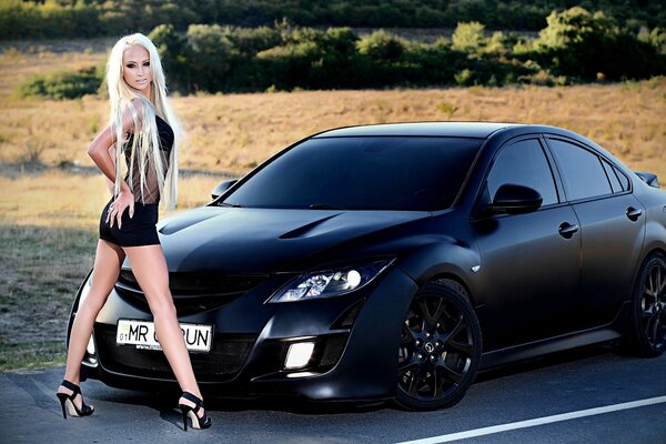 Jeune fille debout sur fond de voiture noire