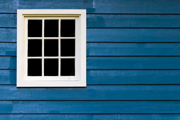 Weißes Fenster im blauen Haus