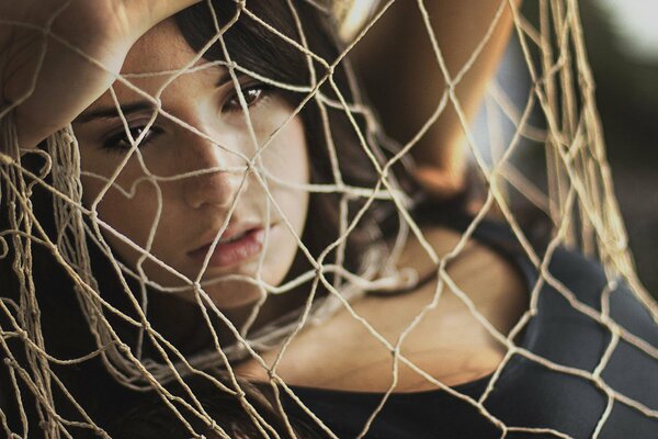 Brunette looking through a large mesh