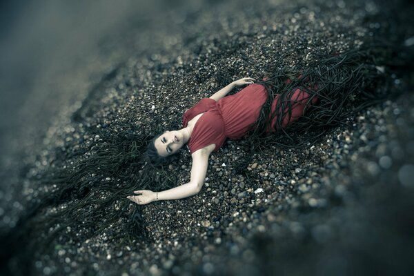 Photo shoot among the sea. the girl in the red dress