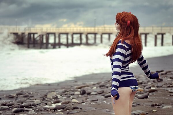 Rousse fille jouit sur la plage de la mer