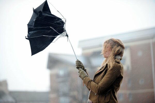 Le mauvais temps, le vent fort a presque emporté le parapluie