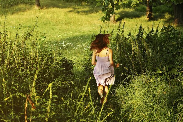 Courir à travers un champ vert et ensoleillé fille