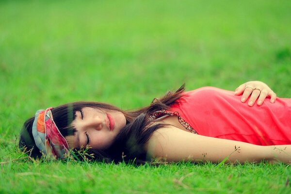 Asiatique couchée sur l herbe les yeux fermés