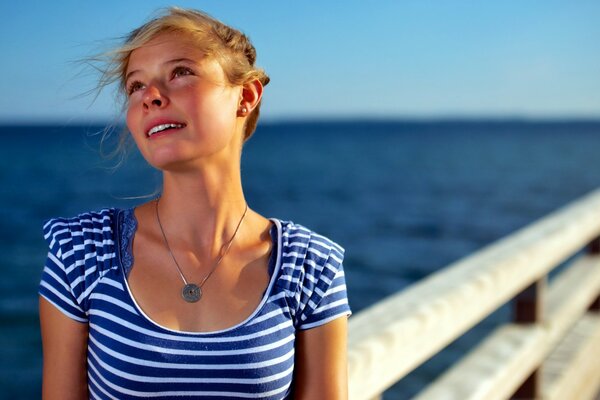 Träumendes Mädchen im T-Shirt am Meer