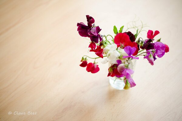 Un ramo de hermosas flores perfumadas en un jarrón sobre una mesa