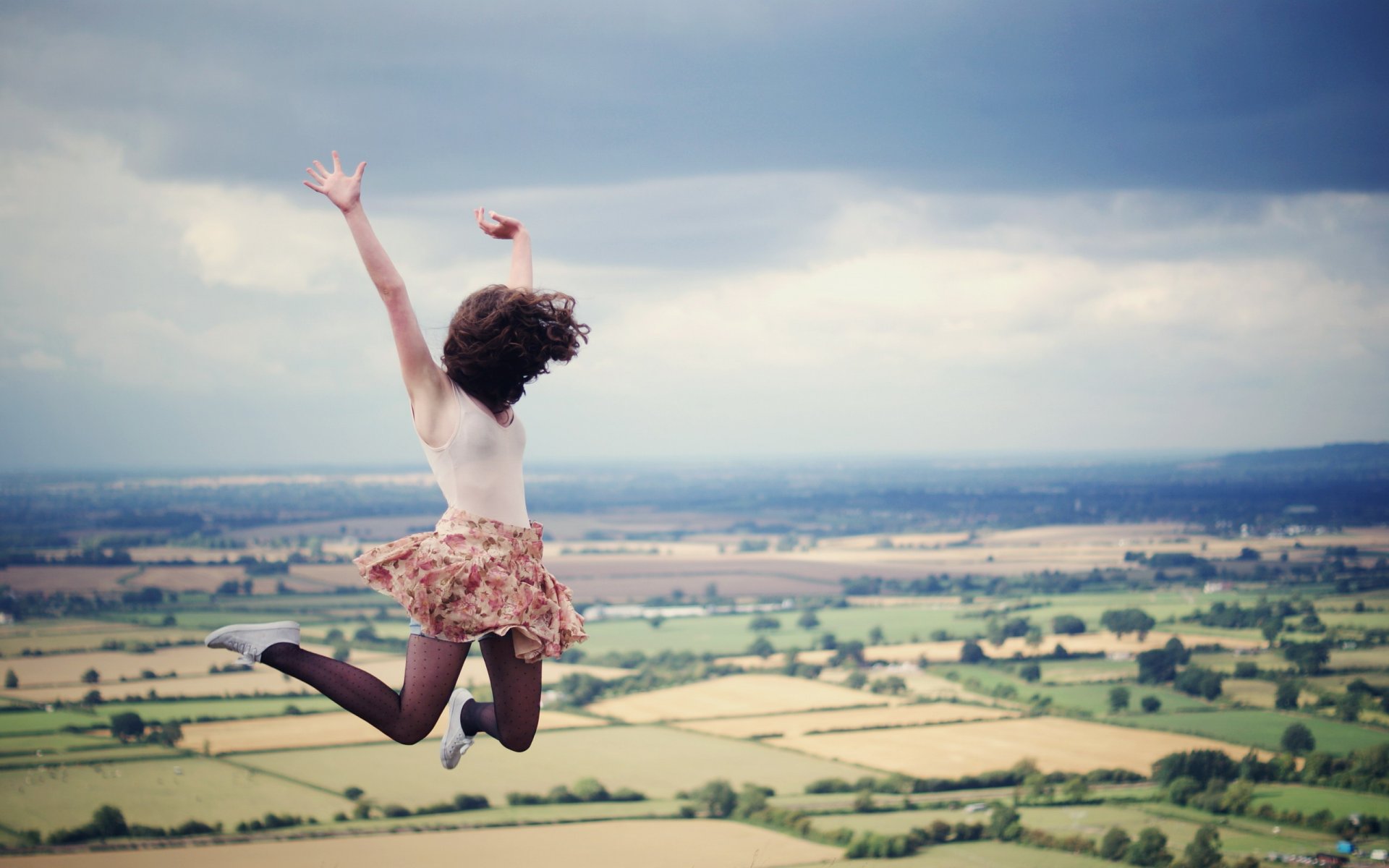 chica salto cielo nube campos pelo falda