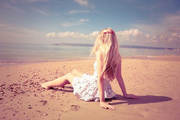 Rubia en la arena en la playa