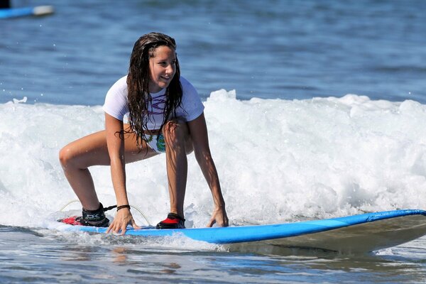 Chica surfista atrapa una ola