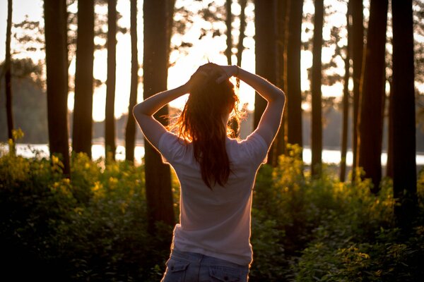 A girl at sunset in the forest