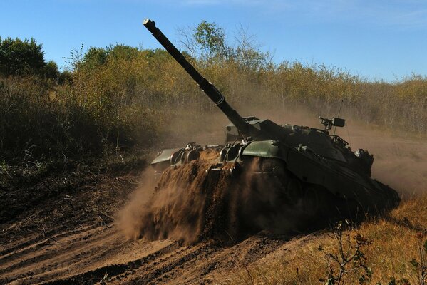 A battle tank moves across the sand