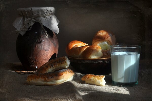 Ein Schatten fällt auf Brötchen mit einem Glas Milch