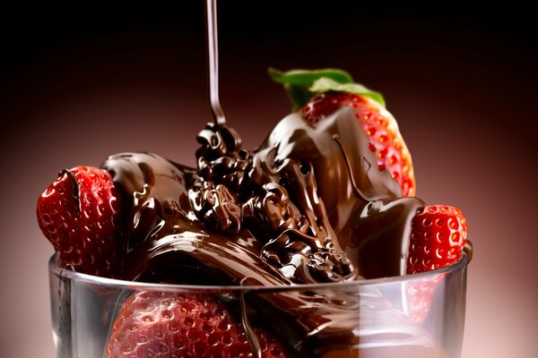 Postre con fresas cubiertas de chocolate. Chocolate que fluye