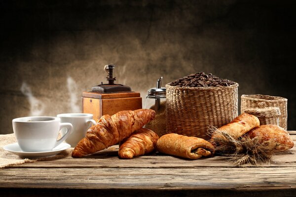 Pain frais à la table avec une tasse de café faite dans un moulin à café