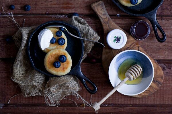 Pancakes served with blueberries and sour cream