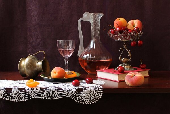 Still life with peaches, cherries, a book and a jug of red liquid