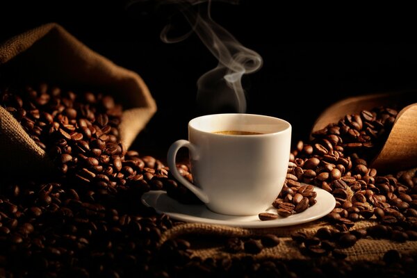 Tasse de café chaud parmi les grains de café